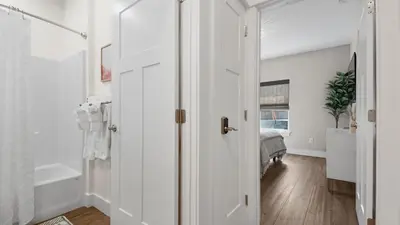 a white hallway with a door leading to a bedroom at Pinetree Paradise! in Panama City Beach