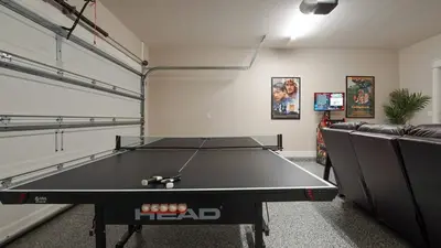 a ping pong table in a room with a couch at Pinetree Paradise! in Panama City Beach