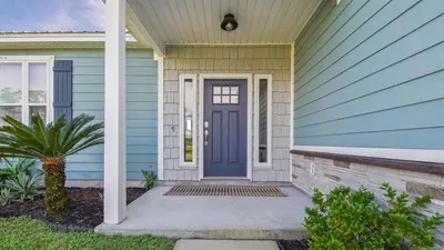 a blue house with a blue door at Guilty Treasure in Panama City Beach
