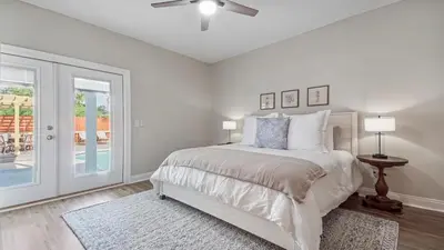 a white bedroom with a bed and a ceiling fan at Guilty Treasure in Panama City Beach