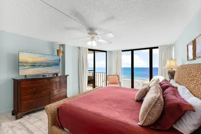 a bedroom with a bed with a red bedspread and a dresser at 2BD Edgewater Beach & Golf Resort! Best Amenities! by Dolce Vita Getaways PCB in Panama City Beach