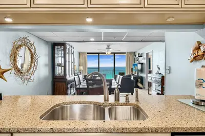 a kitchen with a sink and a view of the ocean at 2BD Edgewater Beach & Golf Resort! Best Amenities! by Dolce Vita Getaways PCB in Panama City Beach