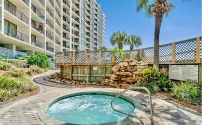a hot tub in front of a large apartment building at 2BD Edgewater Beach & Golf Resort! Best Amenities! by Dolce Vita Getaways PCB in Panama City Beach