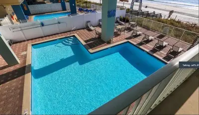 an overhead view of a swimming pool with the beach at Beachfront 3BR Condo! Free Beach Chair Service! by Dolce Vita Getaways PCB! in Panama City Beach