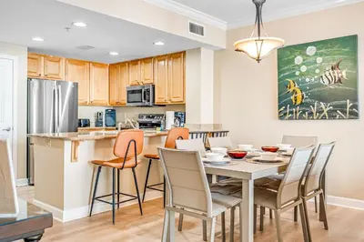 a kitchen and dining room with a table and chairs at Beachfront 3BR Condo! Free Beach Chair Service! by Dolce Vita Getaways PCB! in Panama City Beach