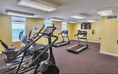 a gym with several tread machines in a room at Beachfront 3BR Condo! Free Beach Chair Service! by Dolce Vita Getaways PCB! in Panama City Beach
