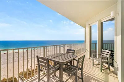 a balcony with a table and chairs and the ocean at Beachfront 3BR Condo! Free Beach Chair Service! by Dolce Vita Getaways PCB! in Panama City Beach