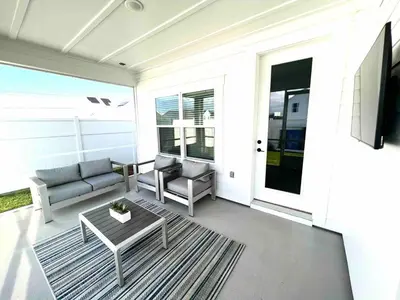 a porch with a couch and a table and a tv at R3 at Lake Powell near Panama City Beach and 30A in Panama City Beach