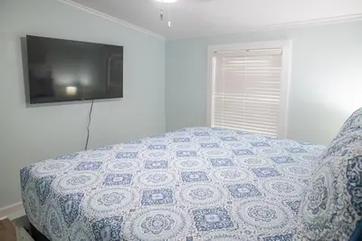 a bedroom with a bed with a tv on the wall at R3 Orange at Inlet Beach with Pool, EV Connector and RV Parking in Inlet Beach