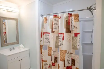 a bathroom with a shower curtain and a sink at R3 Orange at Inlet Beach with Pool, EV Connector and RV Parking in Inlet Beach