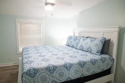 a bedroom with a bed with a blue comforter and a pillow at R3 Orange at Inlet Beach with Pool, EV Connector and RV Parking in Inlet Beach
