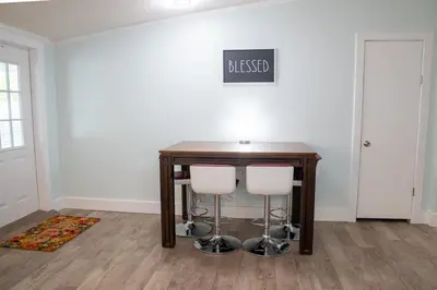 a table with two white stools in a room at R3 Orange at Inlet Beach with Pool, EV Connector and RV Parking in Inlet Beach