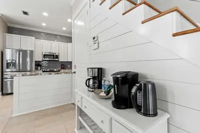 a kitchen with white cabinets and a counter with a coffee maker at Laid Back in Inlet Beach