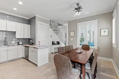 a kitchen and dining room with a wooden table and chairs at Laid Back in Inlet Beach