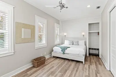 a white bedroom with a bed and two windows at Laid Back in Inlet Beach