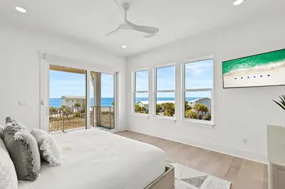 a white bedroom with a large bed and windows at The Luxe Lookout in Inlet Beach