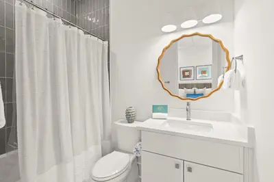 a bathroom with a toilet and a sink and a mirror at The Luxe Lookout in Inlet Beach