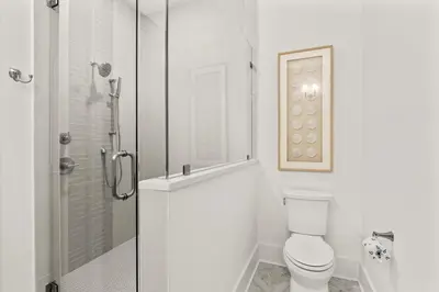 a white bathroom with a toilet and a shower at The Luxe Lookout in Inlet Beach