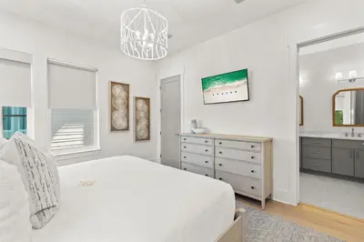 a white bedroom with a bed and a sink at The Luxe Lookout in Inlet Beach