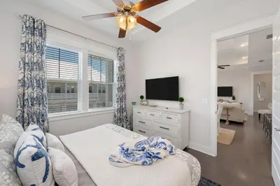 a bedroom with a bed and a ceiling fan at Sea - Esta Prominence 30A! BESIDE POOL! 6 seater LSV! 4 Bikes Sleeps 6! in Watersound Beach