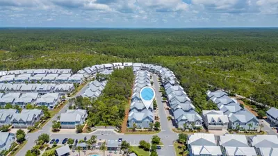 an aerial view of a resort with buildings and trees at Sea - Esta Prominence 30A! BESIDE POOL! 6 seater LSV! 4 Bikes Sleeps 6! in Watersound Beach
