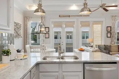 a kitchen with two sinks and a living room at Sea - Esta Prominence 30A! BESIDE POOL! 6 seater LSV! 4 Bikes Sleeps 6! in Watersound Beach