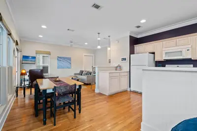a kitchen and living room with a table and chairs at Peacock Cottage in Inlet Beach