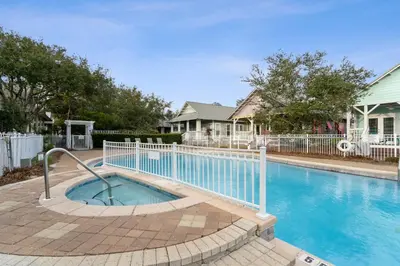 a swimming pool with a white fence around it at Peacock Cottage in Inlet Beach