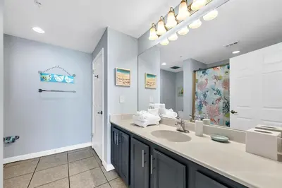 a bathroom with a sink and a large mirror at Sterling Reef 1404 in Panama City Beach