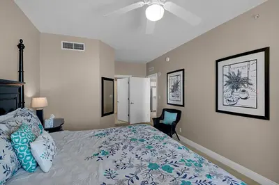 a bedroom with a bed with blue and white pillows at Calypso 2-2108 West in Panama City Beach