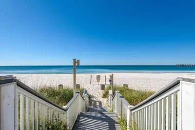 a stairway to the beach with the ocean in the background at Calypso 2-2108 West in Panama City Beach