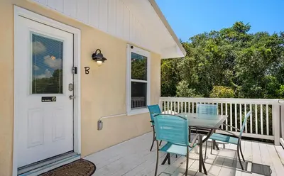 a porch with a table and chairs on a deck at Sand Dollar B by Emerald Coast Retreats in Panama City Beach