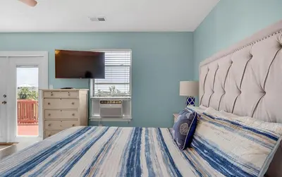 a bedroom with a large bed with a large headboard at Sand Dollar B by Emerald Coast Retreats in Panama City Beach