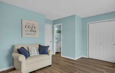 a living room with a couch and blue walls at Sand Dollar B by Emerald Coast Retreats in Panama City Beach