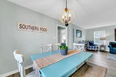 a kitchen and dining room with a blue table and chairs at Sand Dollar B by Emerald Coast Retreats in Panama City Beach