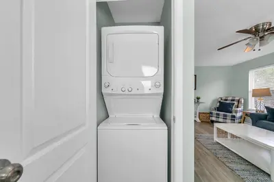a white washer and dryer in a living room at Sand Dollar B by Emerald Coast Retreats in Panama City Beach