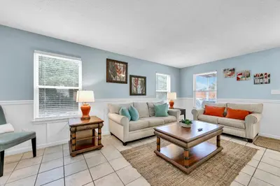 a living room with two couches and a table at Sand Dollar A by Emerald Coast Retreats in Panama City Beach