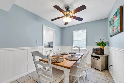 a dining room with a ceiling fan and a table at Sand Dollar A by Emerald Coast Retreats in Panama City Beach