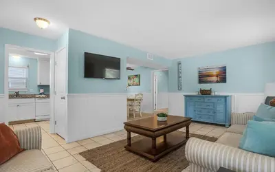 a living room with a couch and a table at Sand Dollar A by Emerald Coast Retreats in Panama City Beach