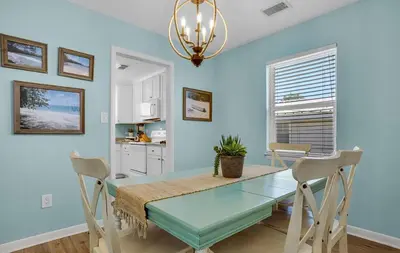 a dining room with a glass table and chairs at Sand Dollar by Emerald Coast Retreats in Panama City Beach