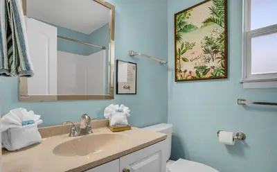 a bathroom with a sink and a toilet and a mirror at Sand Dollar by Emerald Coast Retreats in Panama City Beach