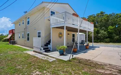 a house with a porch and stairs on it at Sand Dollar by Emerald Coast Retreats in Panama City Beach