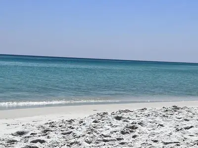 a sandy beach with the ocean in the background at A Wave From It All in Laguna Beach Large Patio Sleeps 4 Dog Ok in Panama City Beach