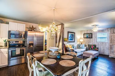 a kitchen and living room with a table and chairs at A Wave From It All in Laguna Beach Large Patio Sleeps 4 Dog Ok in Panama City Beach