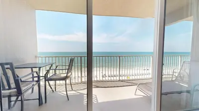 a balcony with a table and chairs and the ocean at Tidewater 0509 in Panama City Beach