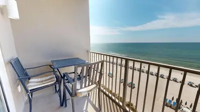 a balcony with a table and chairs and the ocean at Tidewater 0509 in Panama City Beach