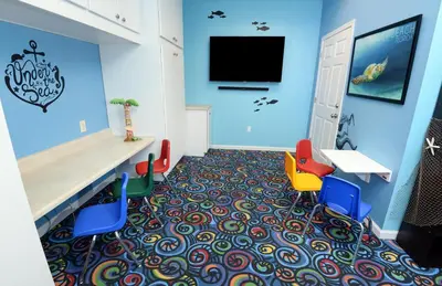 a waiting room with colorful chairs and a flat screen tv at Tidewater 0509 in Panama City Beach