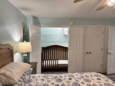 a bedroom with a bed and a room with a crib at Watercrest 1510 - Timeless Memories Stunning views in Panama City Beach
