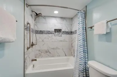 a white bathroom with a tub and a toilet at Watercrest 1510 - Timeless Memories Stunning views in Panama City Beach
