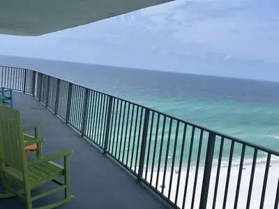 a balcony with a green chair and the ocean at Watercrest 1510 - Timeless Memories Stunning views in Panama City Beach